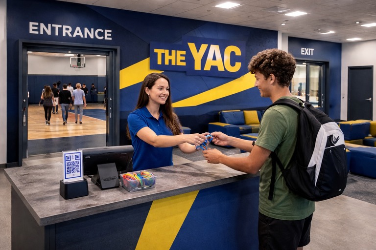THE YAC entrance and reception desk with staff member helping youth at check-in