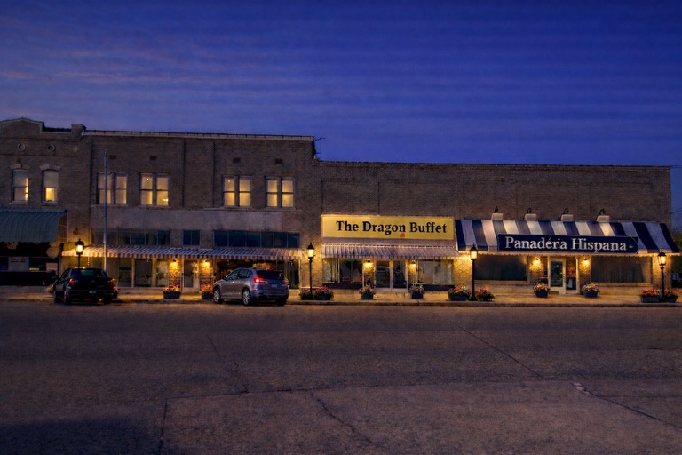Dragon Buffet and Panadera Hispana downtown storefront evening view showcasing diverse local dining and businesses